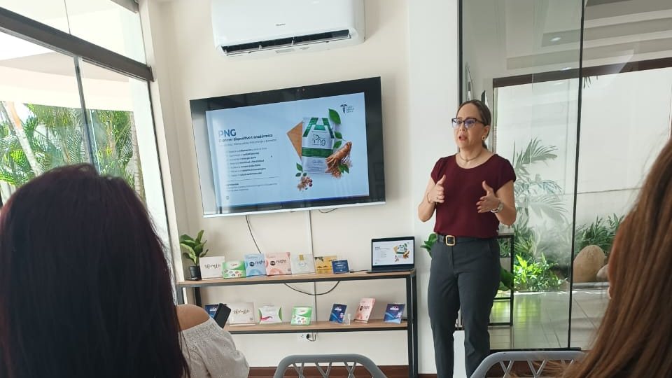 Reunión informativa de One More: una expositora presenta los productos ante un grupo de personas sentadas